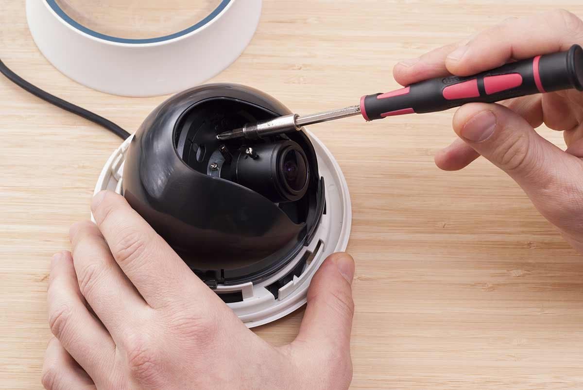 Technician servicing the internal components of a dome security camera