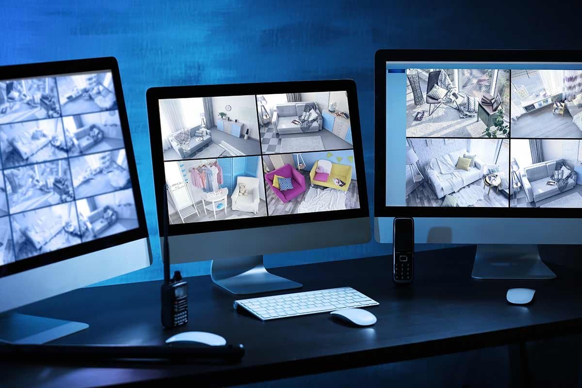 Multi-screen monitoring station displaying live camera feeds